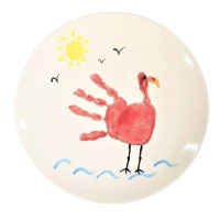 Image of a coupe dinner plate ceramic blank painted with a colourful bird design made from a handprint