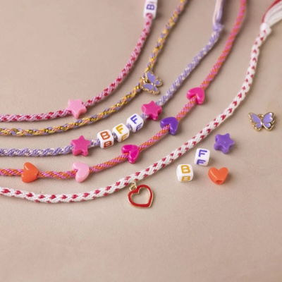 Close-up of colourful friendship bracelets made with beads, hearts, stars and letter charms – part of our jewellery making kits for kids and DIY crafts